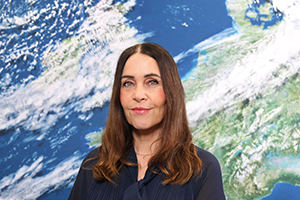 Porträt Annette Friese vor der Rückwand mit dem Motiv Satellitenbild (Quelle DWD)